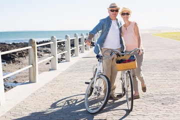 Happy casual couple going for a bike ride on the pier