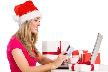 Festive blonde shopping online with laptop