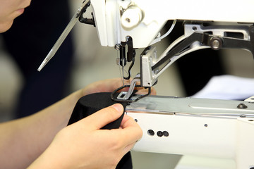 Seamstress sews material on the sewing machine