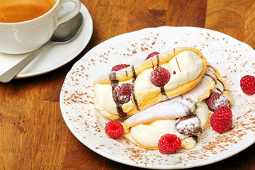 Sweet dessert cake with whipped cream and raspberries in chocola