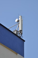 Fototapeta na wymiar Cellular communication aerial on a building roof 