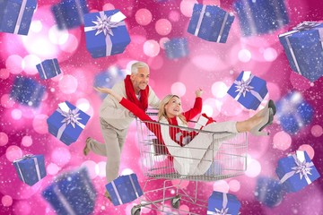 Composite image of happy festive couple messing in trolley