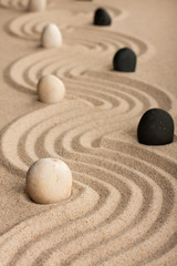 Fototapeta na wymiar line black and white stones, standing on the sand