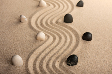 Fototapeta na wymiar line black and white stones, standing on the sand