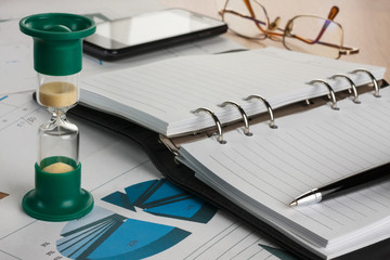 Hourglass, diary, pen, glasses and phone