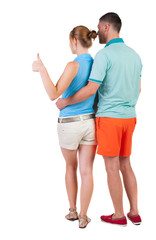 young couple pointing at wal Back view