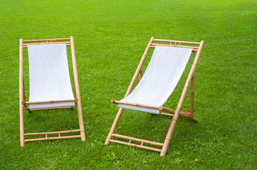 two folding chairs in a green park
