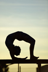 women contortionist practicing gymnastic yoga in silhouette