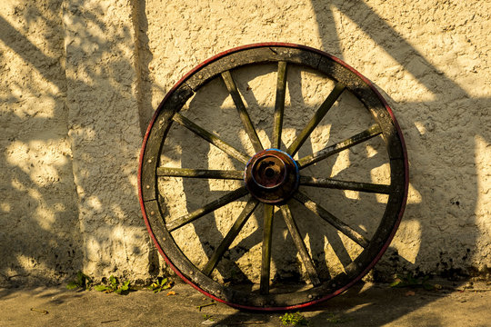 Old wooden wheel standing against the wall