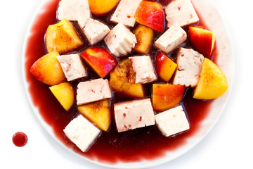 cheese and peaches in red wine sauce, dessert isolated on white
