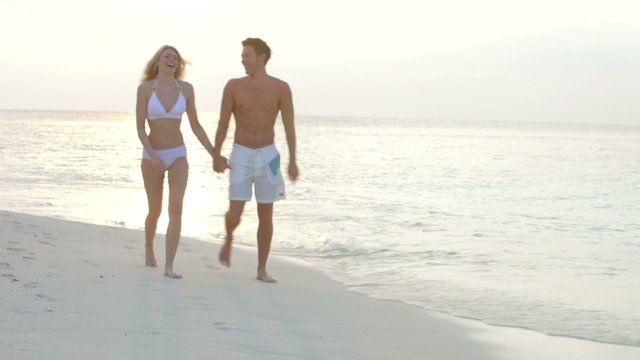 Romantic Couple Walking On Beautiful Tropical Beach 