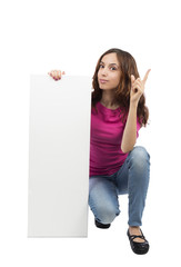 Young woman with an advertisement billboard pointing up