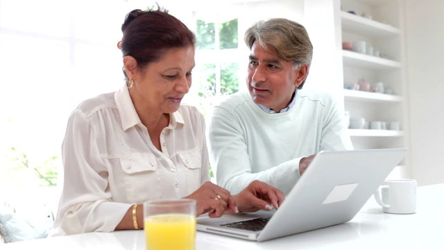 Senior Indian Couple Using Laptop Computer At Home