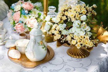 Flowers, teapot, sugar and marshmallows on a tray on the table