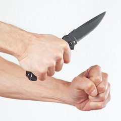Hand position to attack with a army knife on a white background