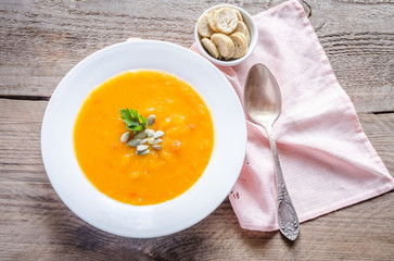 Portion of pumpkin cream soup on the wooden table