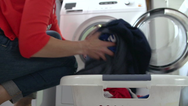Woman Unloading Clothes From Washing Machine
