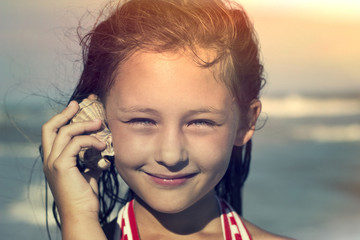 child listens to a seashell