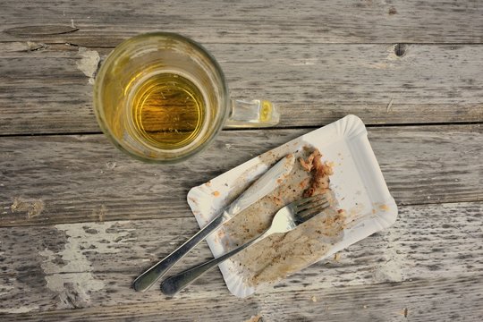 Leerer Pappteller und Bierglas