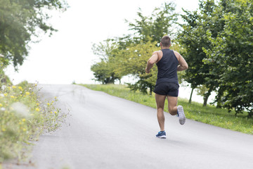 Fototapeta premium Athletic man running uphill, outdoor.