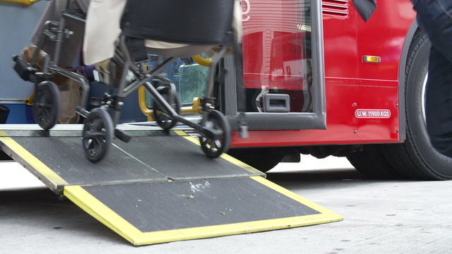 Close Up Of Disabled Person In Wheelchair Boarding Bus
