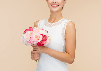 smiling woman in white dress with bouquet of roses