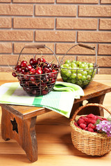 Fresh berries in baskets on wall background