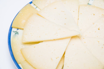 plate with slices of spanish manchego cheese
