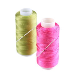 Needles and spools of thread isolated on white