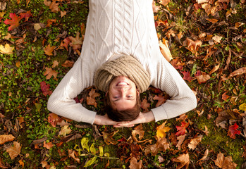 smiling young man lying on ground in autumn park
