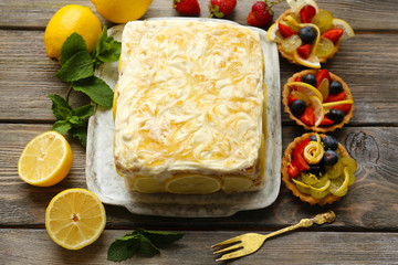 Tasty lemon cake on table at home