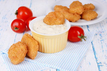 Chicken nuggets with sauce on table close-up