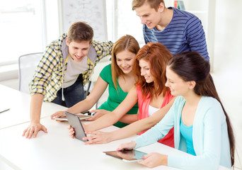 smiling students with tablet pc at school