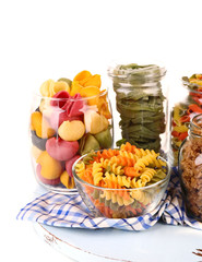Colorful pasta in glass jars isolated on white