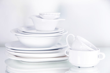 White crockery and kitchen utensils, on light background