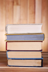 Books on wooden table on wooden wall background