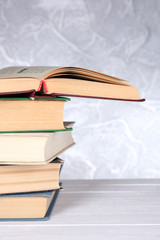 Books on wooden table on light background