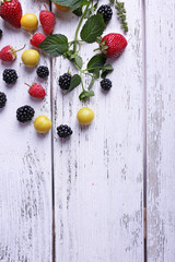 Fototapeta na wymiar Different berries on wooden table close-up