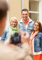 group of smiling friends taking photo outdoors