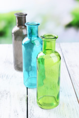 Empty glass bottles on table on bright background