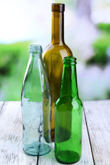Empty glass bottles on table on bright background