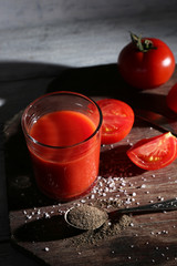glass of tomato juice with spices and fresh tomatoes