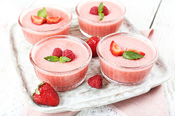 Delicious berry mousse in bowls on table close-up