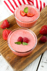 Delicious berry mousse in bowls on table close-up