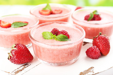 Delicious berry mousse in bowls on table close-up