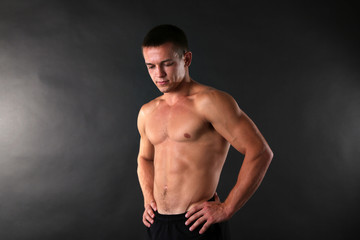 Fototapeta na wymiar Handsome muscle young man on dark background