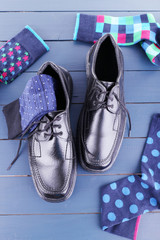 Black man's shoes and socks on dark blue wooden background