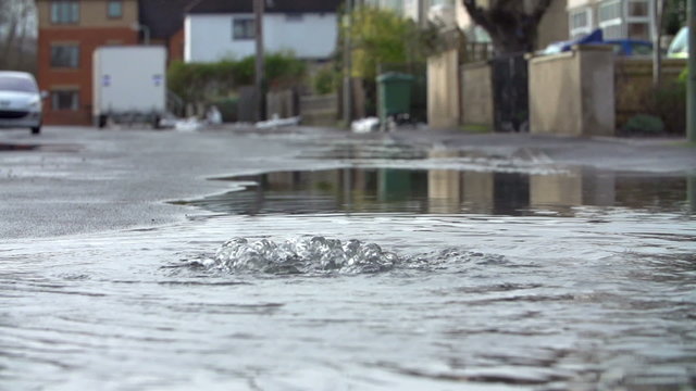 Flood Water Escaping From Drain Cover In Slow Motion
