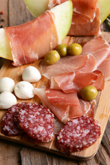 Delicious melon with prosciutto on table close-up