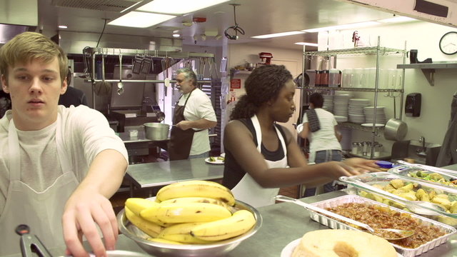 Time Lapse Sequence Of Worker In Kitchen Of Homeless Shelter